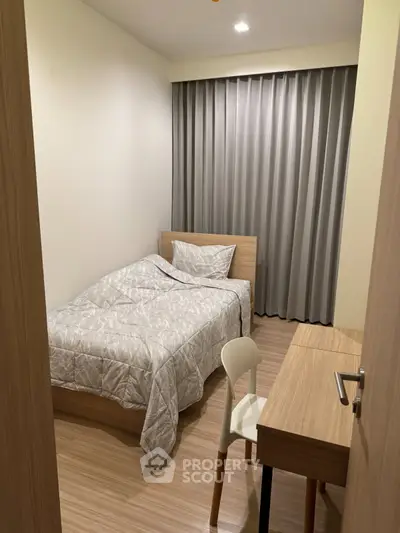 Cozy minimalist bedroom with wooden furniture and soft lighting, perfect for a peaceful retreat.
