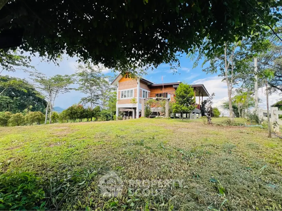 Charming countryside home with lush green surroundings and spacious lawn.