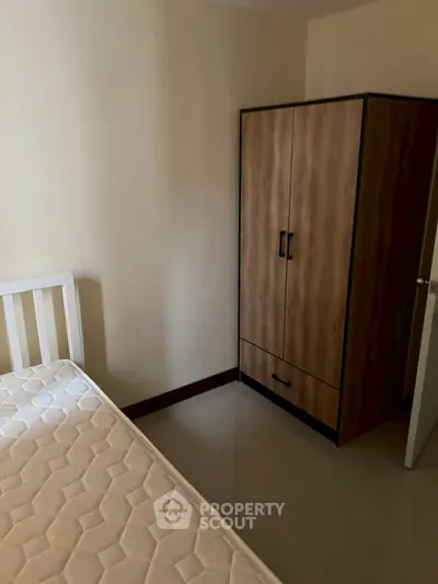 Cozy bedroom with wooden wardrobe and comfortable mattress