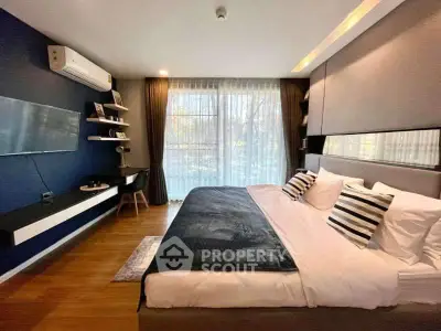 Luxurious bedroom with modern decor and large window offering natural light.