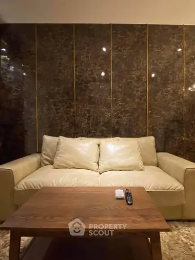 Luxurious living room with elegant marble wall and plush leather sofa