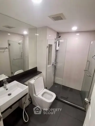 Modern bathroom with glass shower enclosure and sleek fixtures