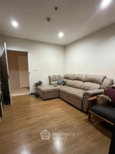 Cozy living room with comfortable sofa and wooden flooring, perfect for relaxation.