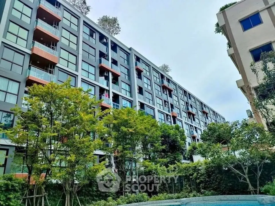 Modern apartment building with lush greenery and pool view