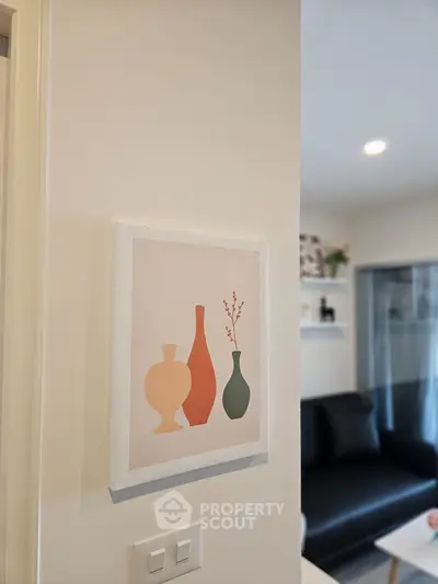 Modern living room with stylish decor and contemporary artwork on the wall.