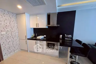 Modern kitchen with sleek black countertops and white cabinets in a stylish apartment.