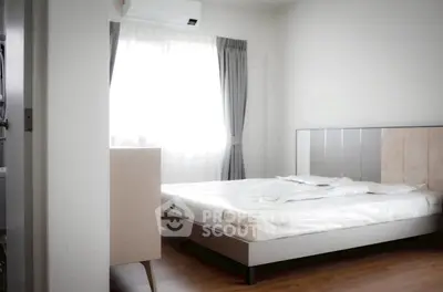 Modern bedroom with natural light, featuring a stylish bed and elegant curtains, perfect for a cozy retreat.