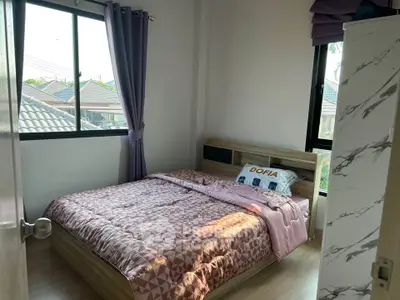Cozy bedroom with large windows and modern decor in a stylish home.