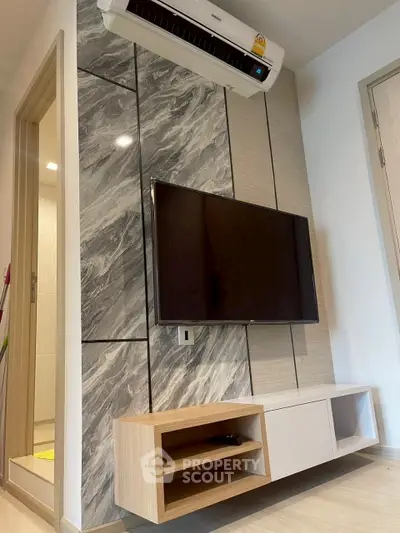 Modern living room with sleek TV setup and stylish wall paneling.