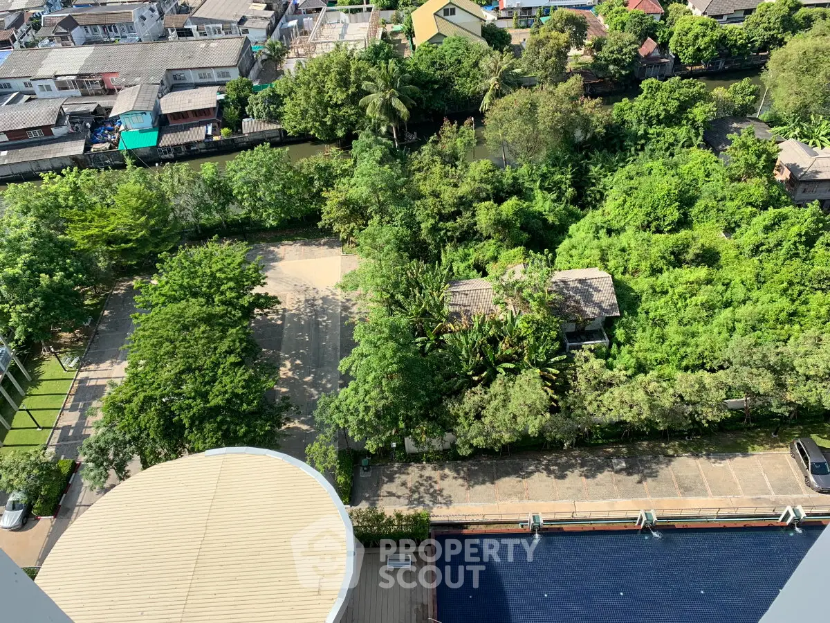 Aerial view of lush green garden and surrounding residential area, showcasing serene urban living.