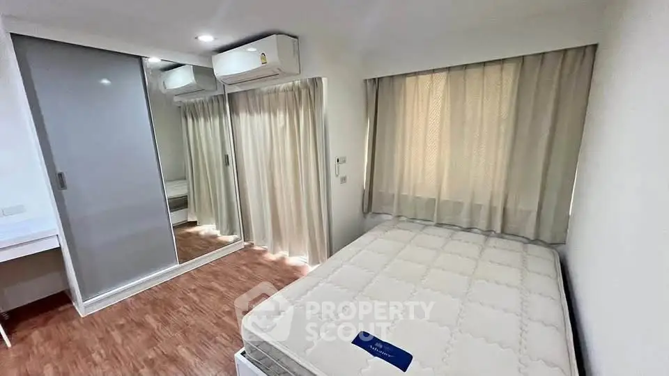 Modern bedroom with mirrored closet and air conditioning in a stylish apartment.