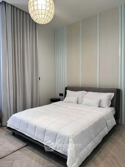 Modern bedroom with stylish decor and cozy bedding in a contemporary apartment.