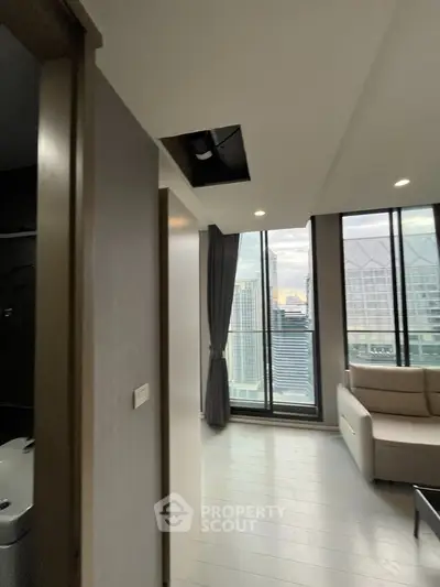 Modern living room with city view and large windows in high-rise apartment