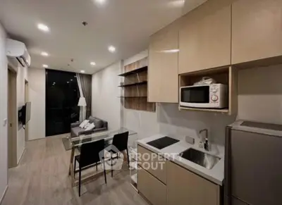 Modern open-plan kitchen and living area with sleek design and cozy ambiance.