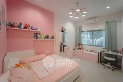 Charming pink-themed bedroom with modern decor and ample natural light.