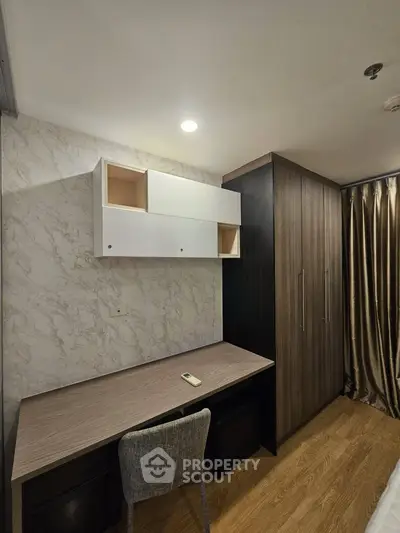 Modern study room with sleek desk, chair, and storage cabinets in stylish apartment.