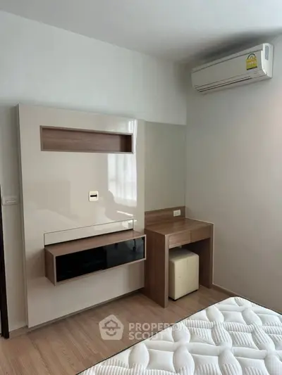 Modern bedroom with sleek built-in furniture and air conditioning unit.