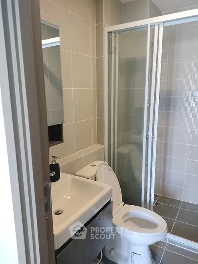 Modern bathroom with sleek design featuring glass shower and contemporary fixtures.