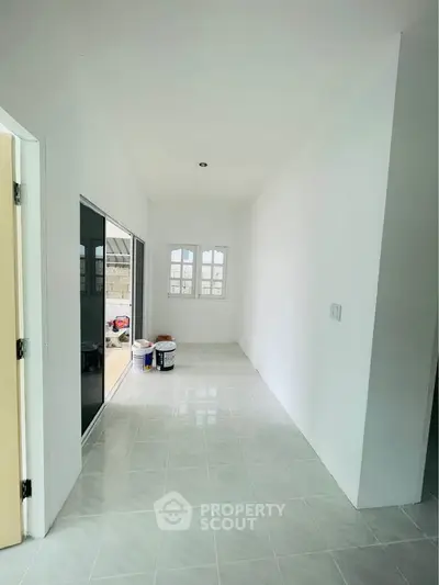 Bright hallway with tiled floor and sliding glass doors leading to outdoor area.