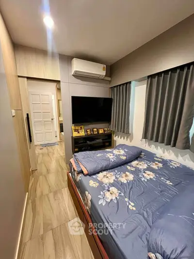 Cozy bedroom with modern decor, featuring a wall-mounted TV and air conditioning for ultimate comfort.