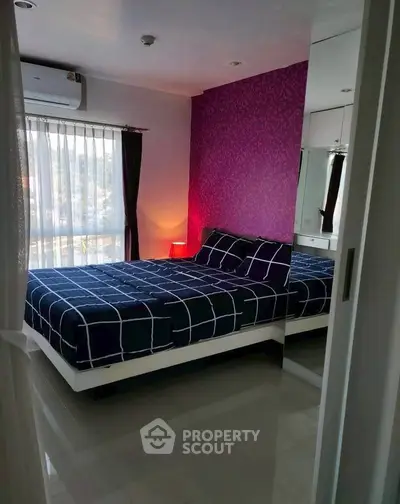 Modern bedroom with stylish decor and large window for natural light.