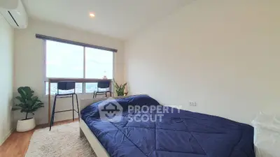 Modern bedroom with large window and stylish decor in high-rise apartment
