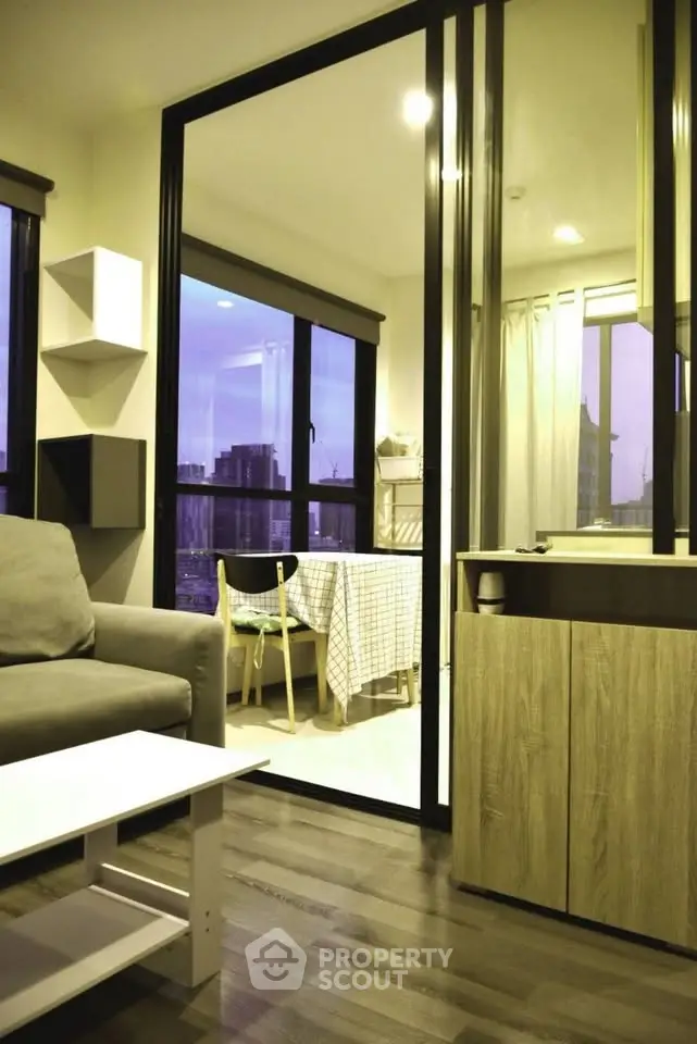 Modern living room with glass partition and city view, featuring cozy seating and dining area.