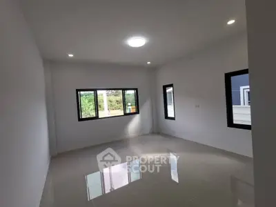 Spacious empty room with large windows and glossy tiled floor