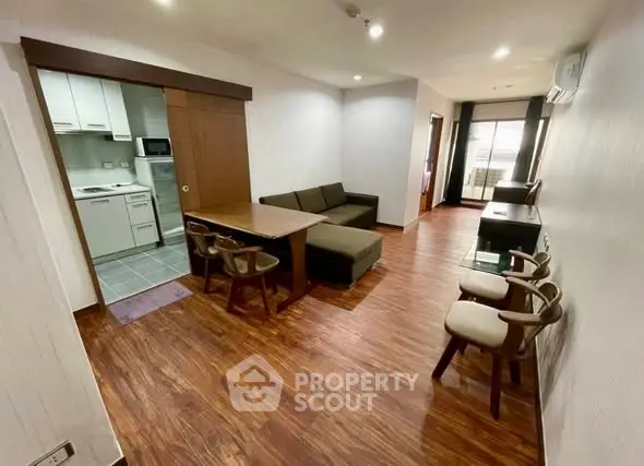 Spacious living room with modern furniture and open kitchen layout in a stylish apartment.