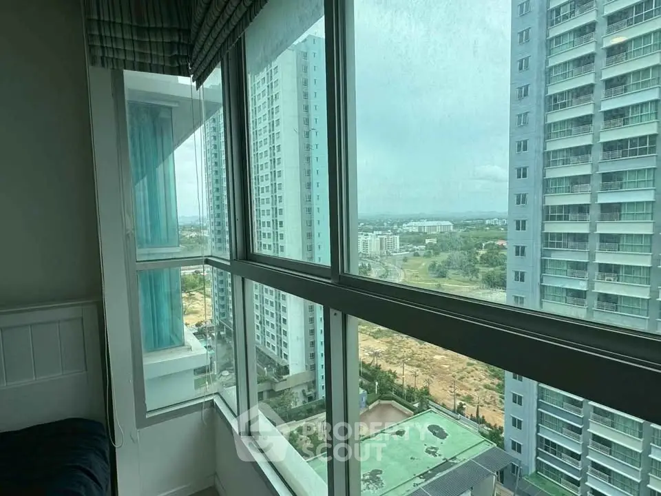 High-rise apartment with expansive city view from large windows, showcasing modern urban living.