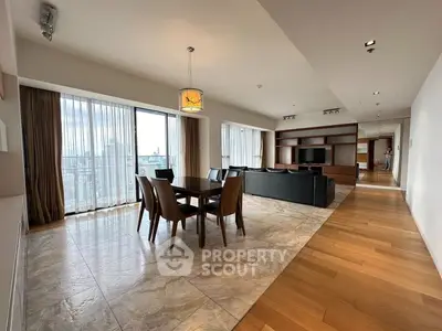 Spacious open-plan living and dining area with city view and modern furnishings.