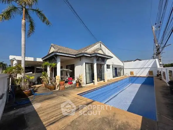 Charming villa with private pool and spacious outdoor area under clear blue sky.