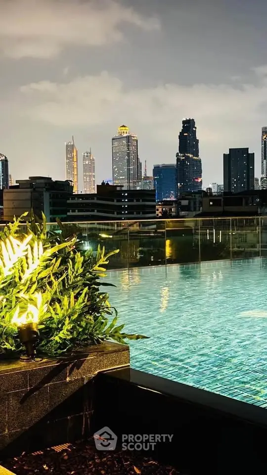 Stunning rooftop pool with breathtaking city skyline view at night.