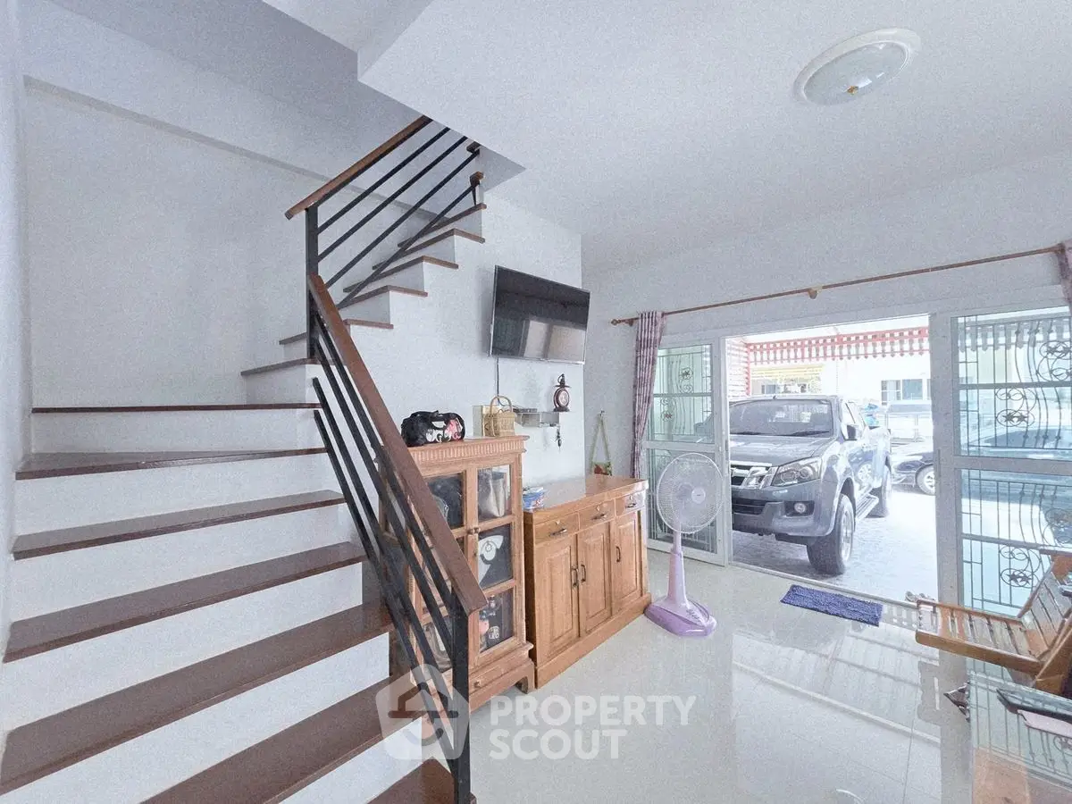 Modern interior with staircase and large window view of parked car