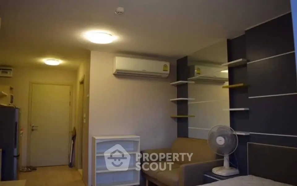 Cozy living room with modern air conditioning and stylish shelving, perfect for urban living.