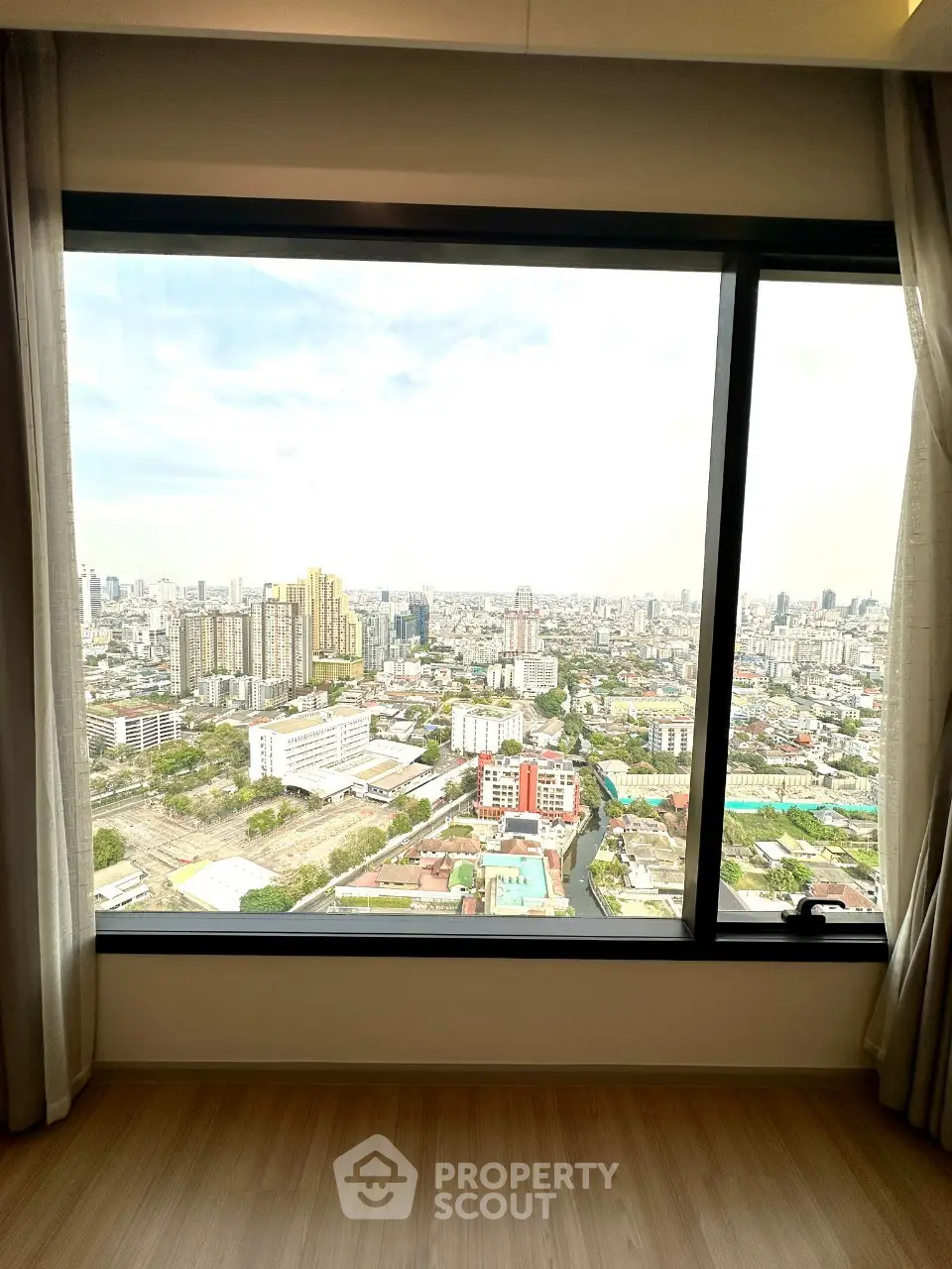 Stunning cityscape view from a high-rise apartment window, showcasing urban living at its finest.