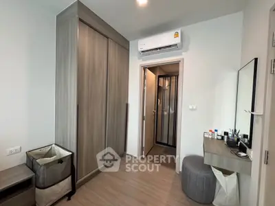 Modern bedroom with sleek wardrobe and air conditioning, featuring minimalist decor and ample storage space.
