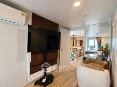 Modern living room with sleek TV setup and stylish decor in a contemporary apartment.
