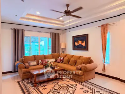 Elegant living room with cozy sectional sofa, ceiling fan, and large windows offering natural light.