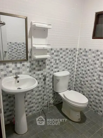 Modern bathroom with pedestal sink and tiled walls in real estate property