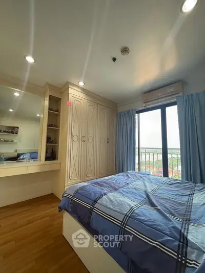 Cozy bedroom with built-in wardrobe and large window offering scenic views.