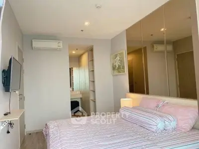 Modern bedroom with stylish decor and wall-mounted TV in a cozy apartment.