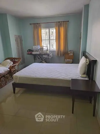 Cozy bedroom with natural light and minimalist decor, perfect for relaxation.