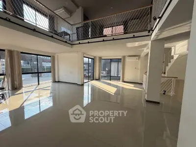 Spacious modern living room with high ceilings and large windows offering abundant natural light.