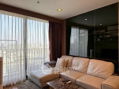 Luxurious living room with leather sofa and city view through large windows.