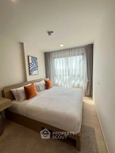 Bright and cozy bedroom with modern decor and large window for natural light.