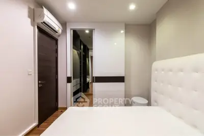 Modern bedroom with sleek design and walk-in closet in luxury apartment