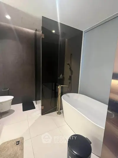 Modern bathroom with sleek design featuring a bathtub and glass shower enclosure.