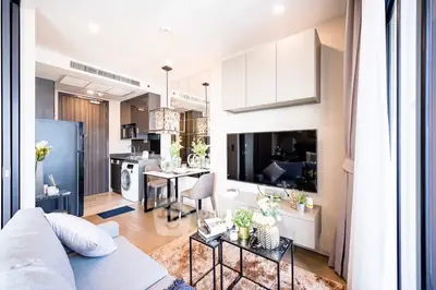 Elegant open-plan living space with modern kitchen, cozy dining area, and inviting living room, bathed in natural light and designed with contemporary furnishings.