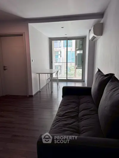 Modern living room with sleek sofa and balcony view in urban apartment